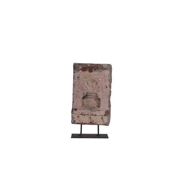 Adorno de piedra rosa en soporte metálico, rostro tallado y textura envejecida