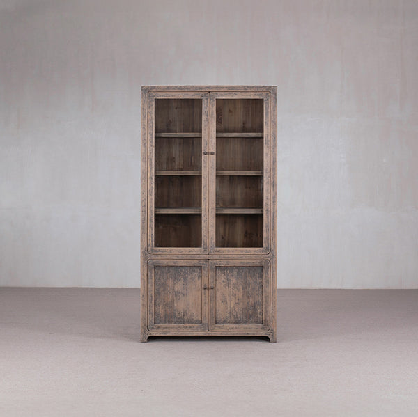 Vitrina de madera con dos puertas de cristal y estantes interiores visibles.