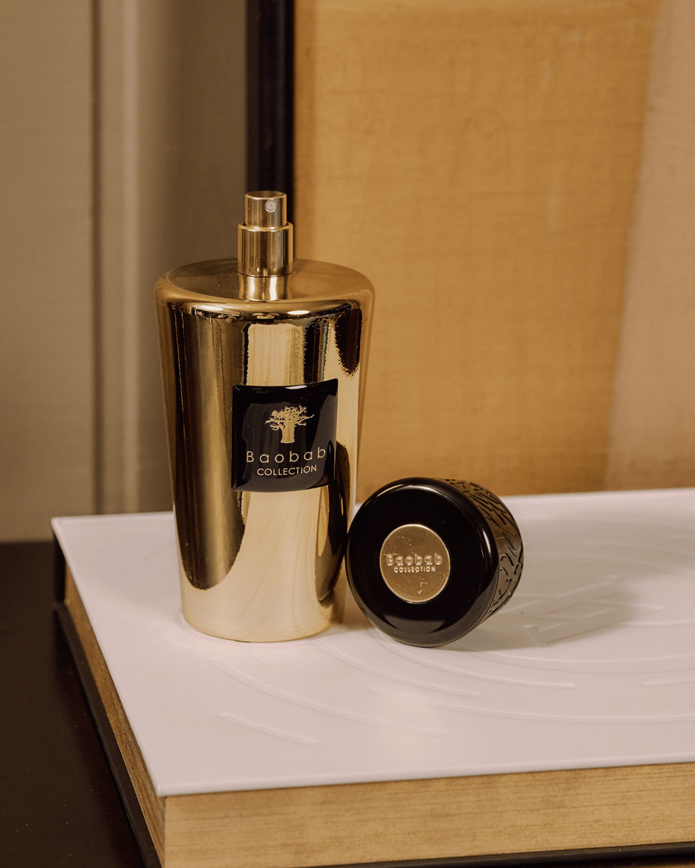 Ambientador en spray Aurum de Baobab Collection, frasco dorado con pulverizador y tapa negra