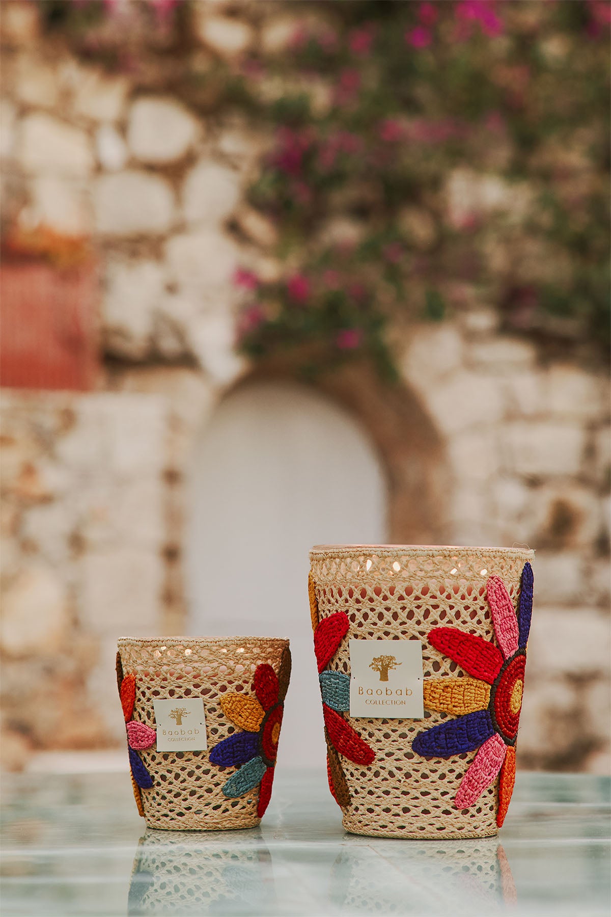 Par de velas en vaso de mimbre beige con flores bordadas multicolor y etiquetas