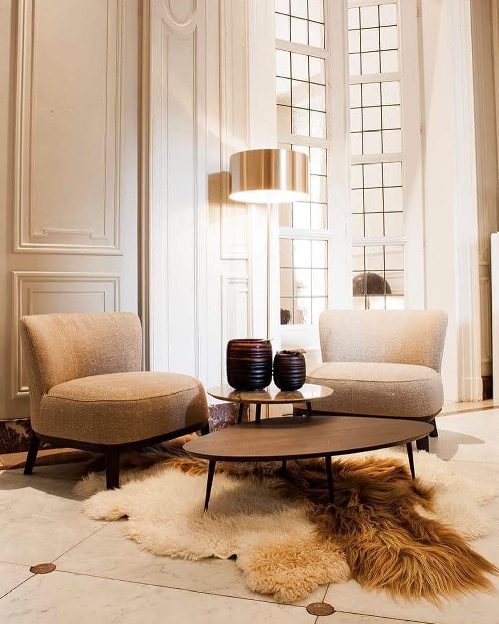 Velas de la marca onno sobre una mesa junto a dos sillones de diseño
