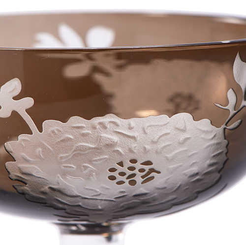 Copa de champagne marrón con relieve de flores y hojas blancas, vista del borde