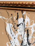 Detalle de cuadro abstracto: marco dorado y trazos con manchas negras y blancas