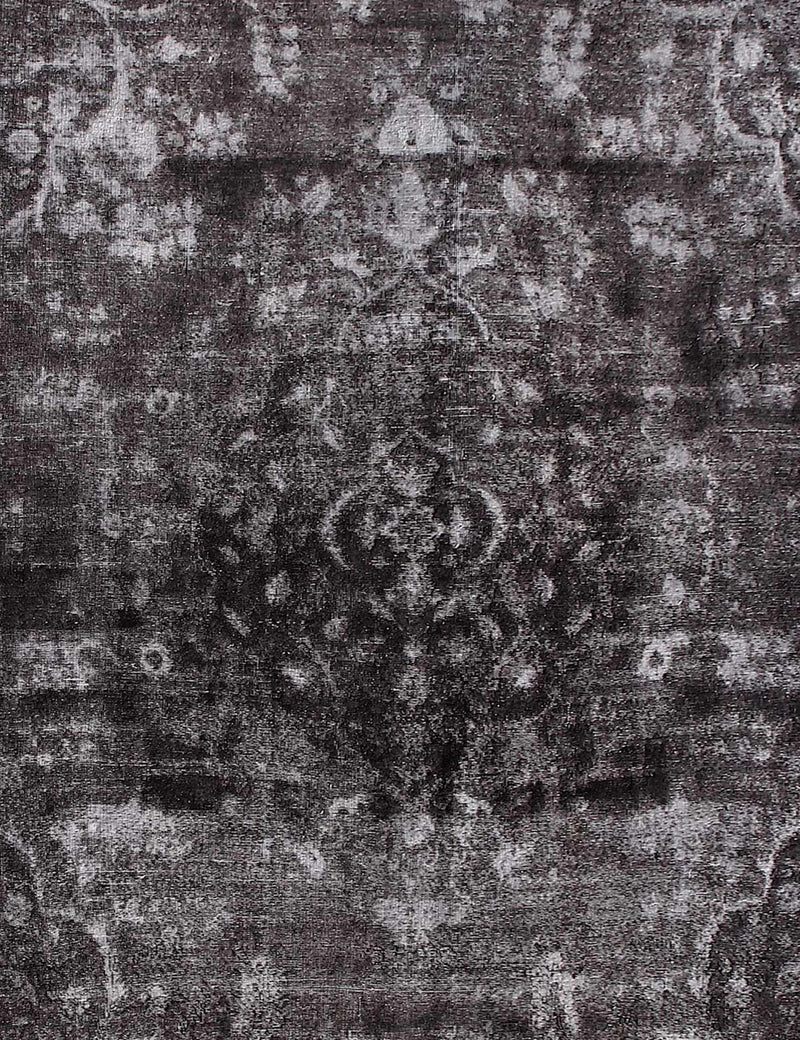 Alfombra vintage persa: detalle del patrón gris y negro con textura envejecida