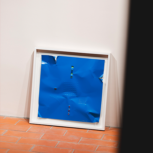 Cuadro de aluminio lacado azul con marco blanco, patrón de puntos y elementos pequeños