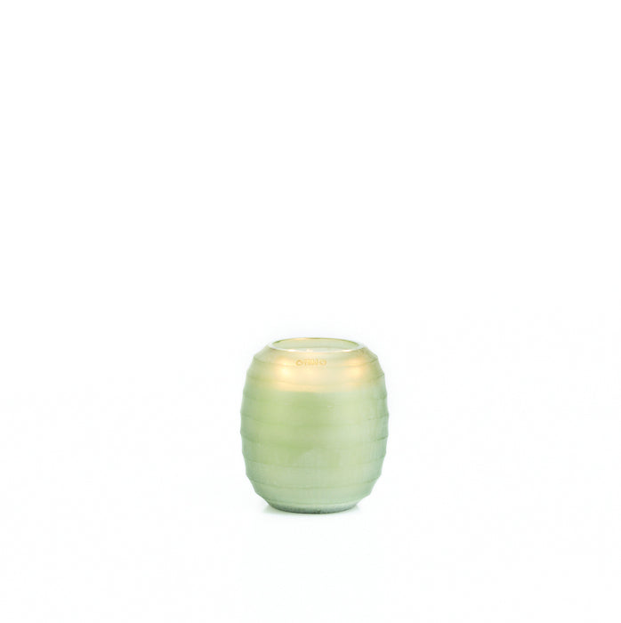 Vela ONNO en vaso verde con bandas horizontales y brillo en la parte superior
