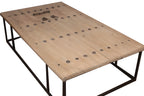 Mesa de centro de madera clara con placa metálica decorativa y base de hierro negro