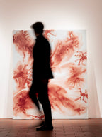 Pintura abstracta roja sobre lienzo claro, con silueta oscura delante