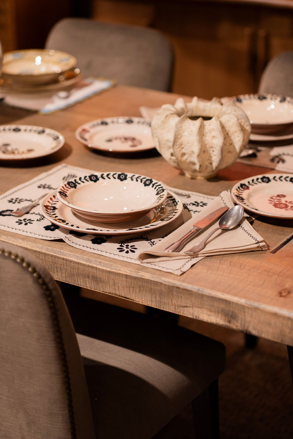 Plato hondo Viana en mesa, con borde floral negro y diseño sobre base clara