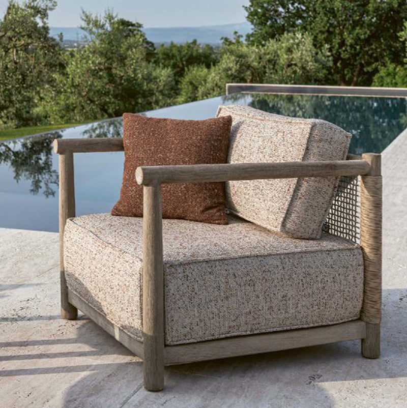 Butaca de teca natural con asiento beige y cojines marrón y gris claro