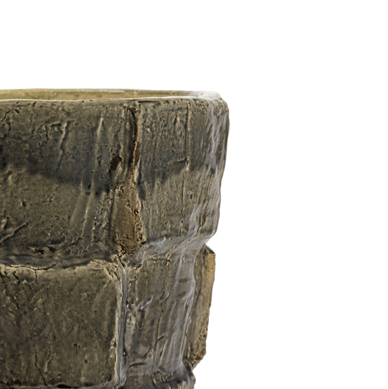 Macetero de cerámica gris oscuro, vista lateral cercana, textura craquelada y relieve