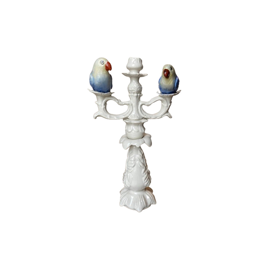 Candelabro de cerámica con dos aves azules sobre base blanca de tres brazos