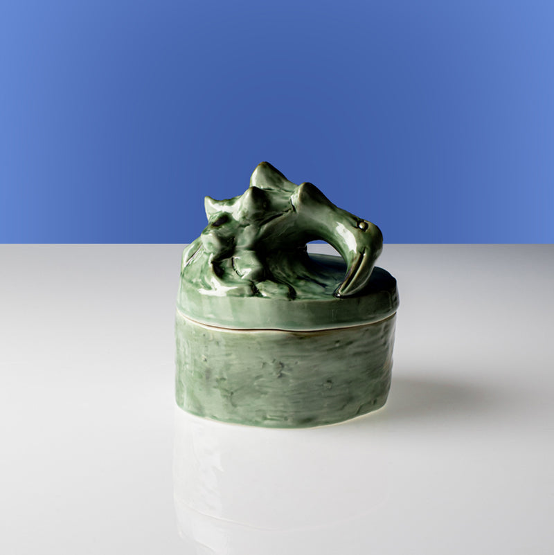 Vela perfumada verde con tapa esculpida de animal y recipiente esmaltado
