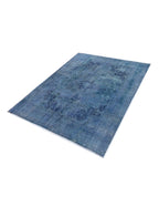 Alfombra vintage persa azul con motivos florales y medallones, bordes decorativos