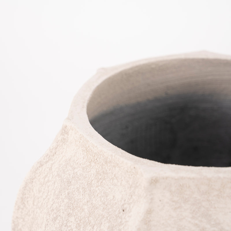 Jarrón de cerámica beige con boca circular; se aprecia el interior oscuro.