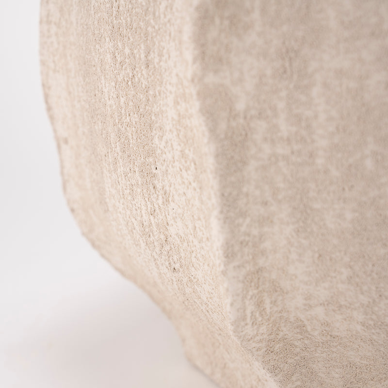 Jarrón de cemento beige, vista lateral con textura arenosa y acabado mate.