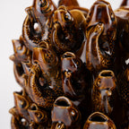 Jarrón cerámico marrón brillante con figuras decorativas tipo peces