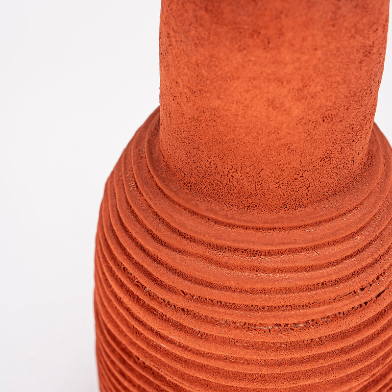 Jarrón de cerámica terracota con textura rugosa y anillos ondulados en el cuerpo