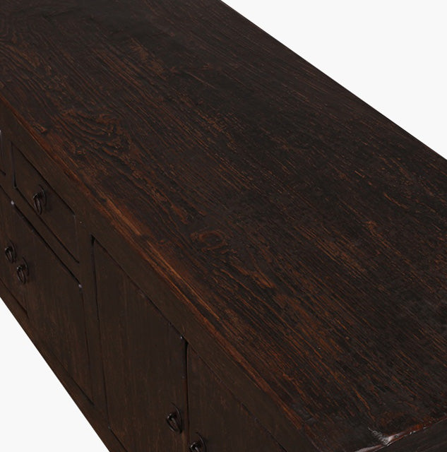 Aparador bajo de madera negro: textura de la tapa y herrajes metálicos