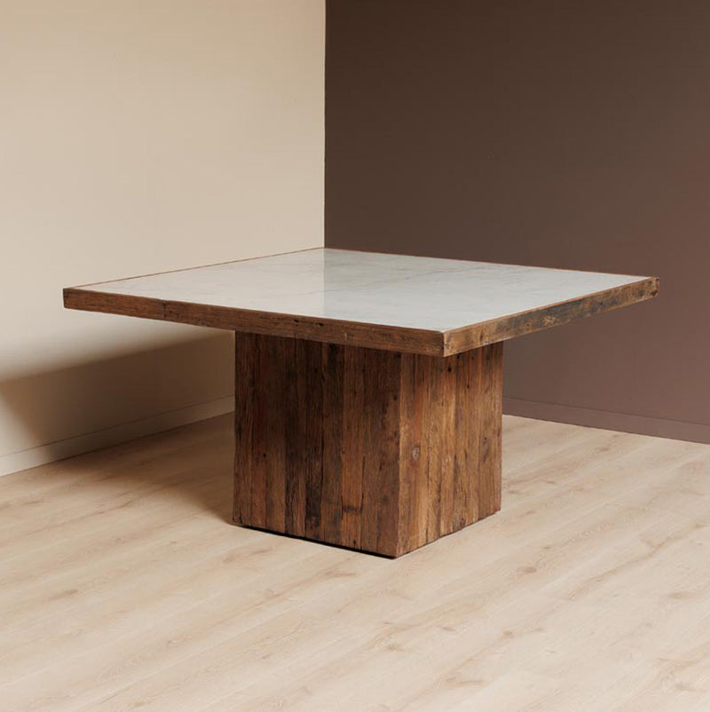 Mesa cuadrada de madera con tapa de mármol claro y base prismática de madera
