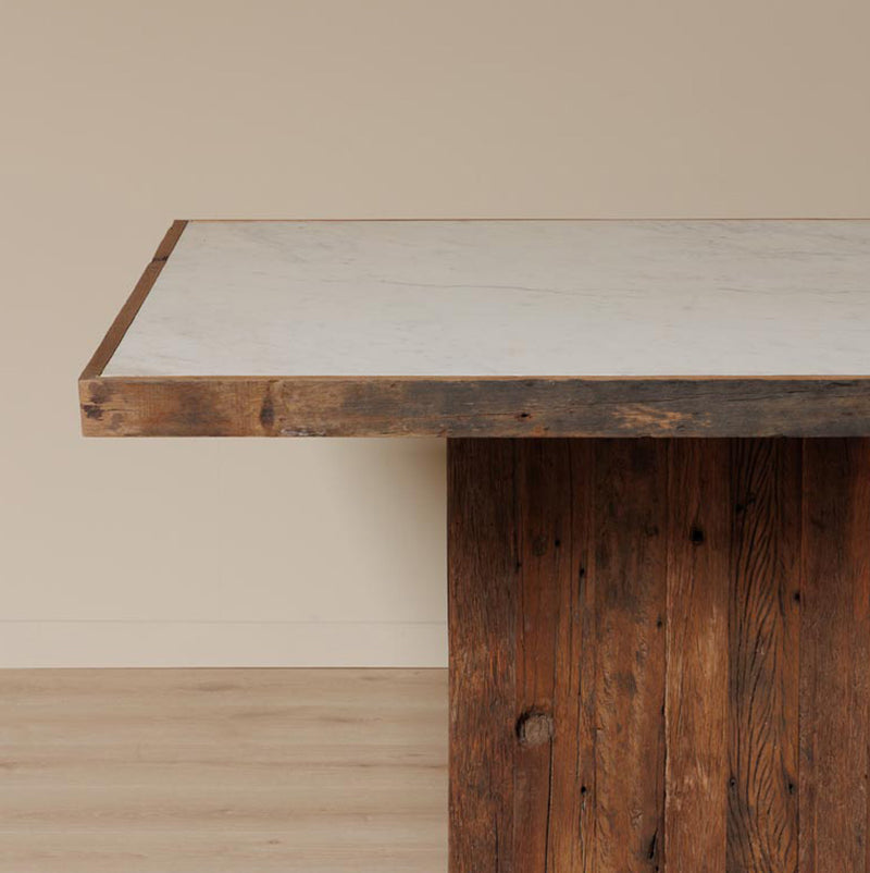 Mesa con tapa de mármol claro y canto de madera, base de tablas