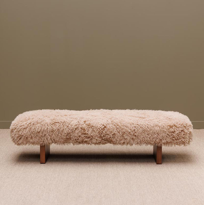 Banco de madera con asiento peludo beige y patas oscuras