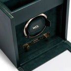 Caja de relojes verde oscuro con vista interior del soporte del reloj y correa enrollada