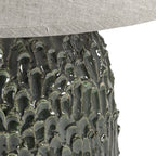 Base de lámpara tronco verde brillante con textura, con pantalla beige visible