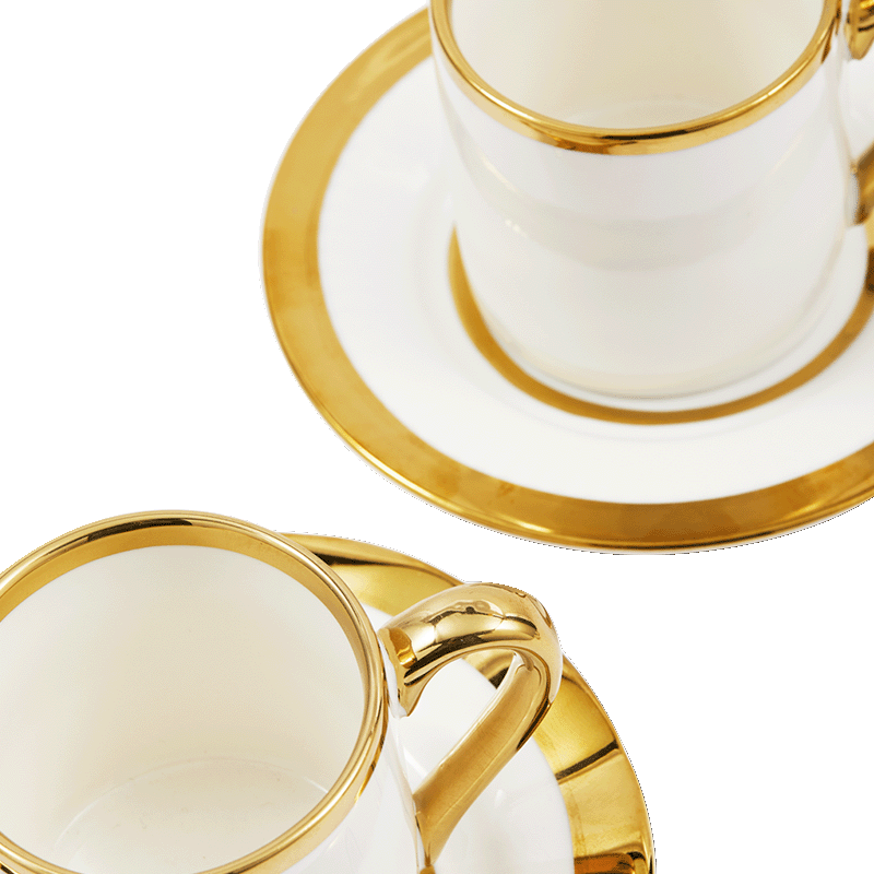 Taza de espresso blanca con borde dorado y asa, sobre plato a juego