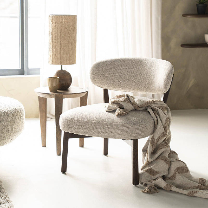 Butaca Mikky tapizada beige con asiento y respaldo redondeados, patas de madera