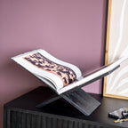 Soporte para libros de madera oscura con libro abierto sobre repisa