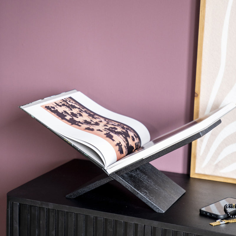 Soporte para libros de madera oscura con libro abierto sobre repisa