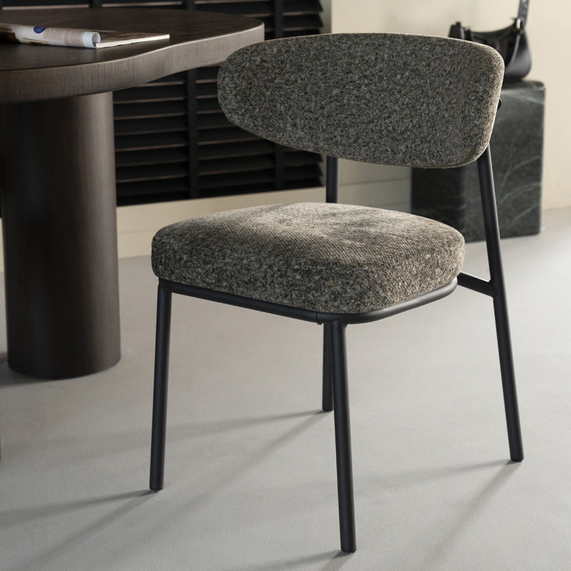 Silla tapizada gris jaspeado con respaldo oval y patas negras de metal.