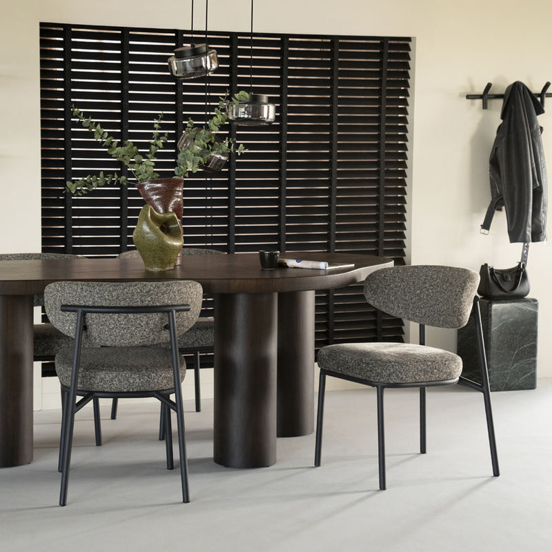 Silla tapizada gris jaspeado con respaldo oval y patas negras de metal.