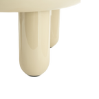 Mesa de centro redonda beige, detalle de una pata cilíndrica y borde del sobre.