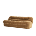 Sofá de tela mostaza con respaldo acolchado capitoné, vista lateral tres cuartos.