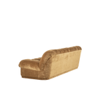 Sofá tapizado en tela mostaza con respaldo alto y reposabrazos, vista lateral alargada.