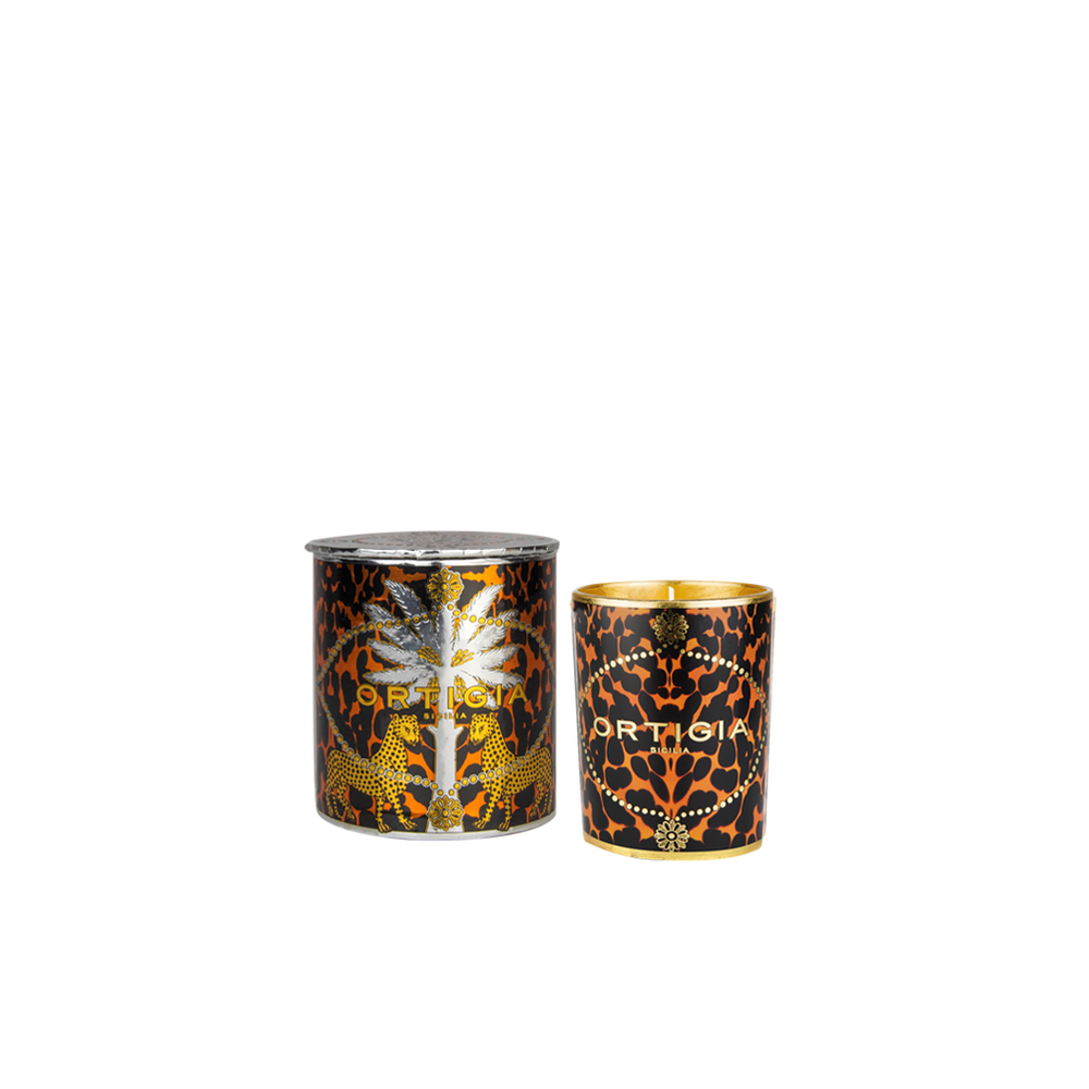 Vela en envase cilíndrico negro con estampado ámbar y dorado, tapa ORTIGIA.
