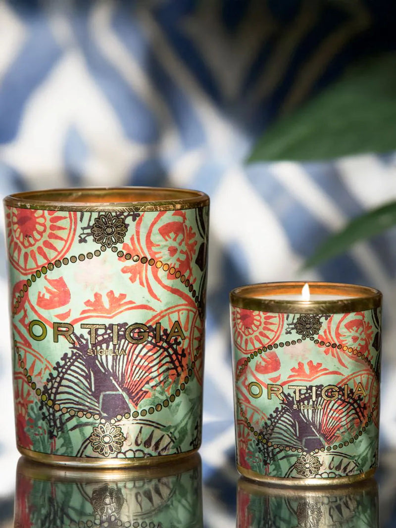 Par de velas aromáticas encendidas en latas con diseño tropical rosa y verde