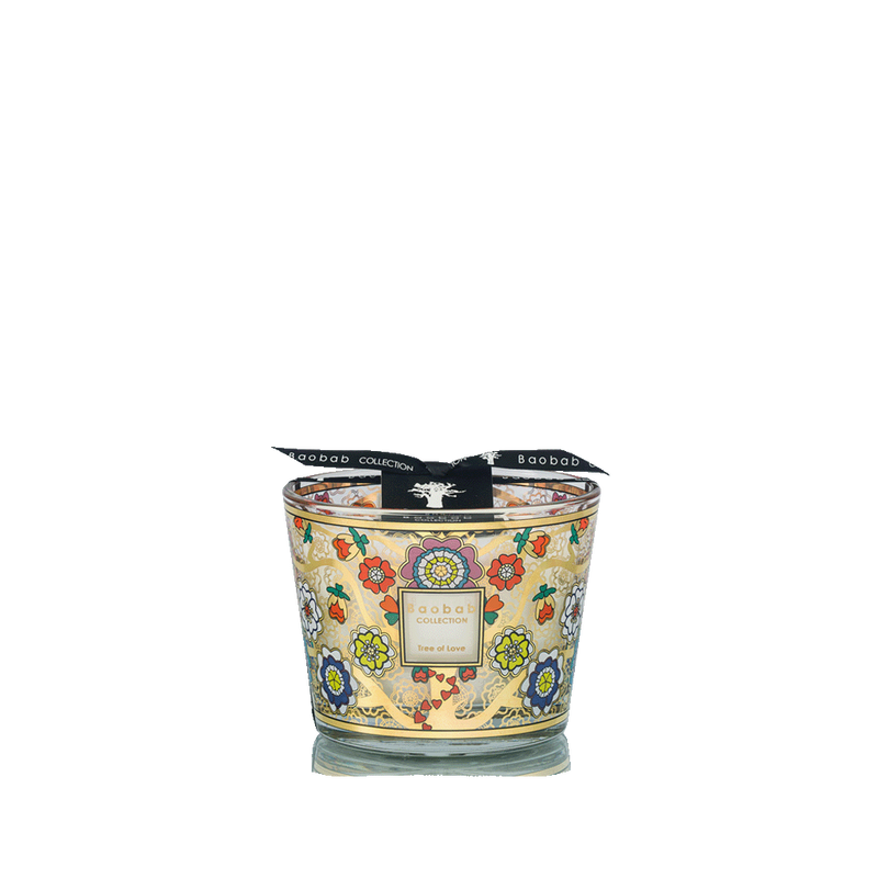 Vela aromática en vaso de vidrio dorado con estampado floral multicolor y corazones