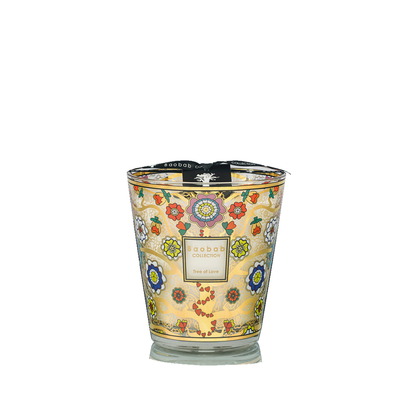 Vela aromática en vaso de vidrio con etiqueta central y estampado floral multicolor