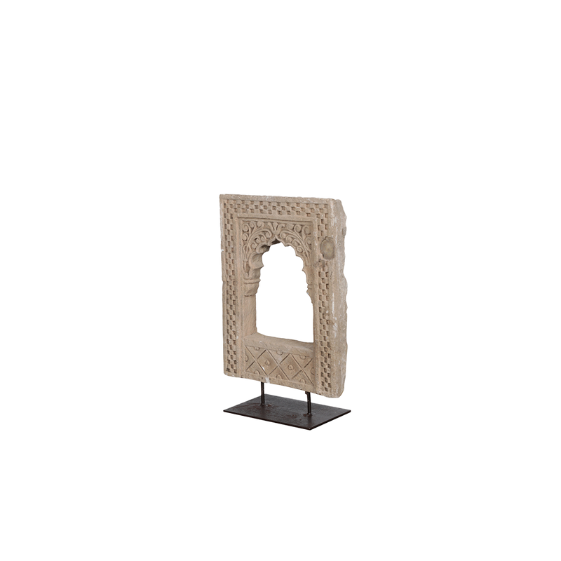 Adorno de piedra beige con relieve geométrico y ventana arqueada en soporte