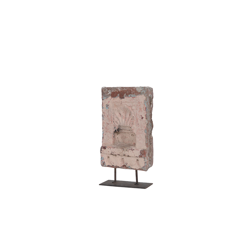 Adorno de piedra rosa tallado, visto en ángulo con soporte metálico