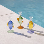 Candelabros de cristal con peces, uno azul, otros verde y amarillo