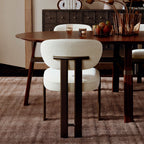 Silla tapizada bouclé beige con respaldo de barra y patas de madera oscura