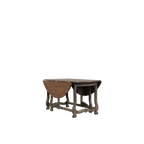 Mesa de comedor redonda con tablero de madera marrón y patas de metal