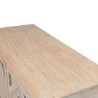 Tapa de madera clara con textura y detalle tallado en relieve geométrico