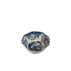 Tazón de cerámica azul y blanco con bordes ondulados y motivo floral central