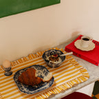 Tazón de cerámica azul y blanco con estampado, sobre mesa con mantel a rayas