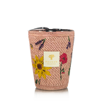 Vela en recipiente trenzado rosa con flores bordadas y etiqueta Baobab Collection centrada.